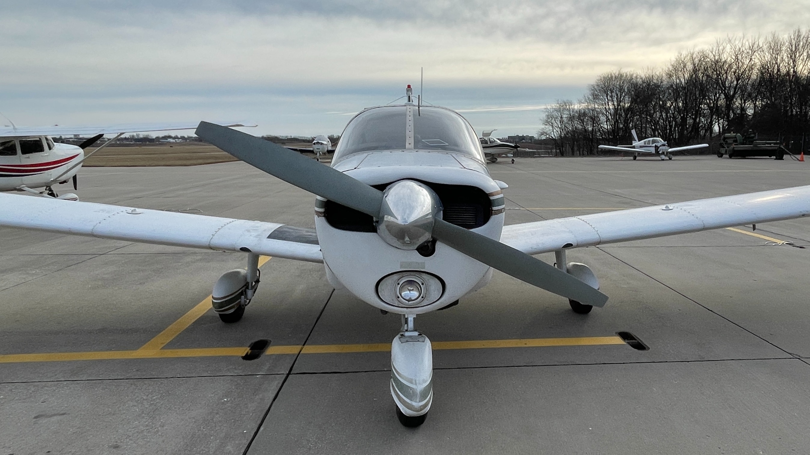 Front view of a piper aircraft parked on a runway.